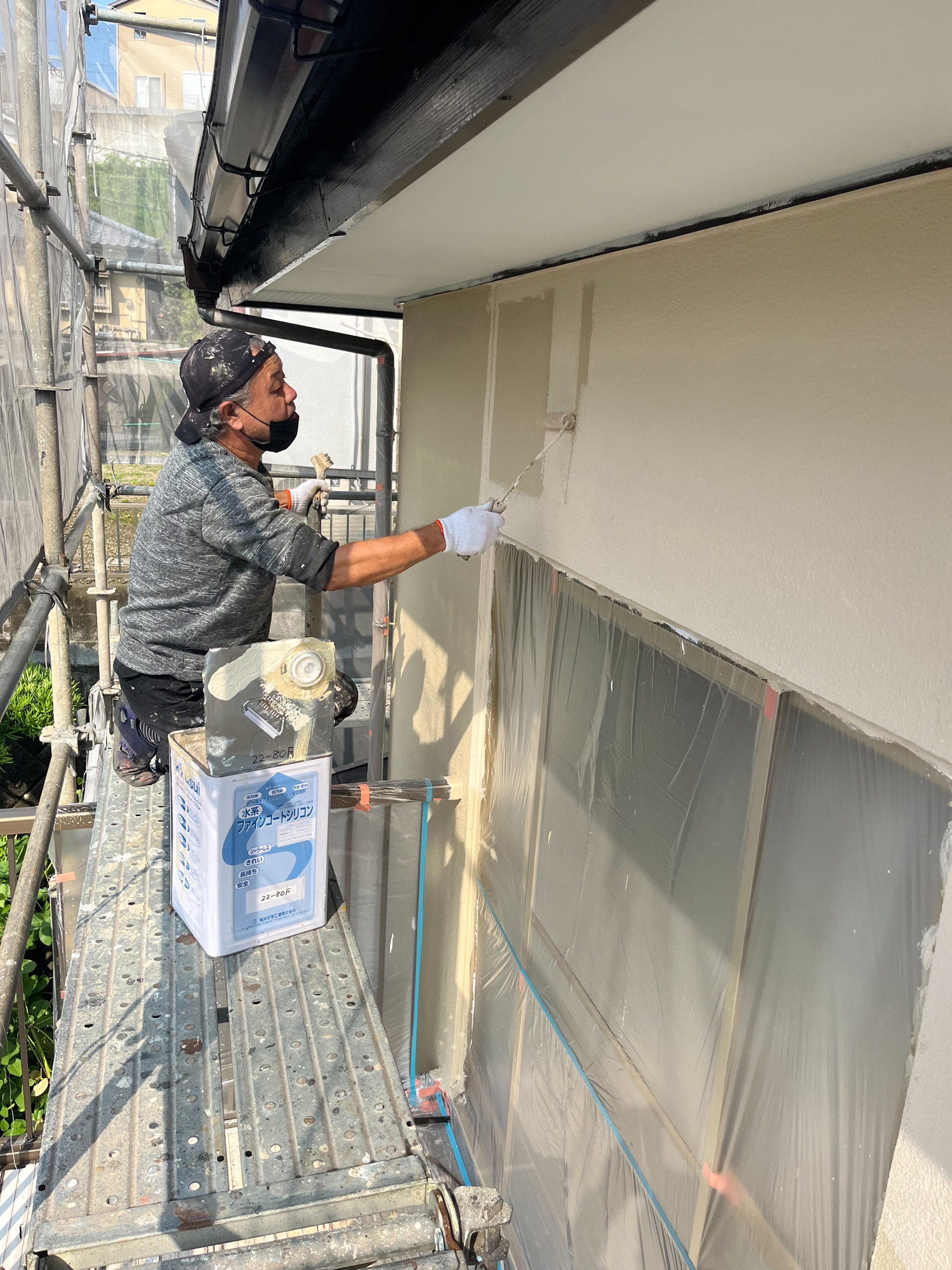 外壁の塗装作業を行う塗装職人